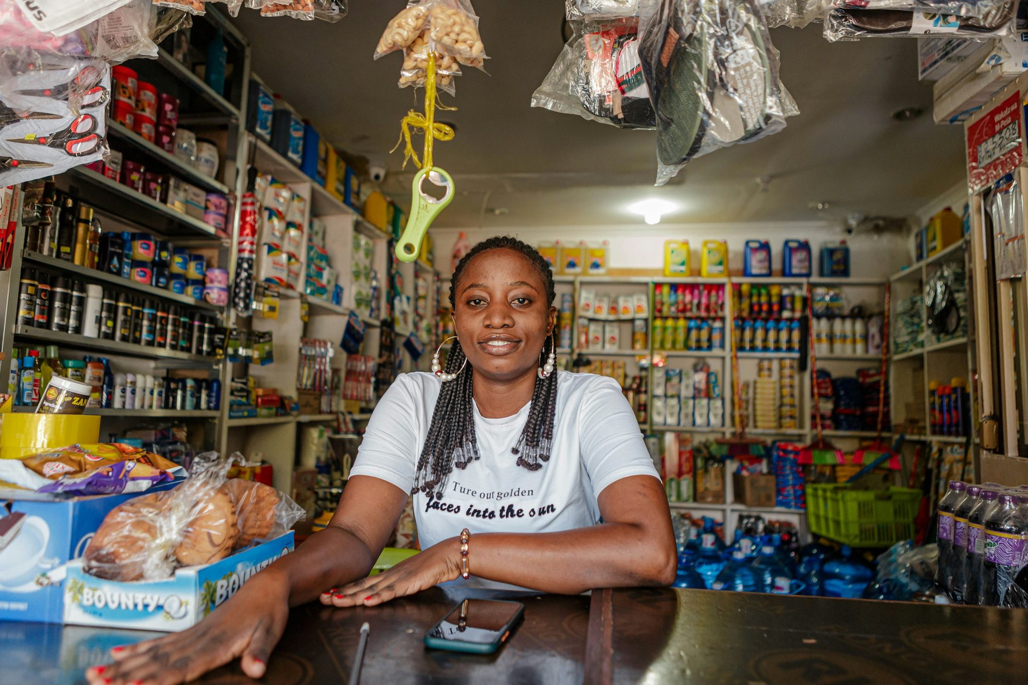 A shop owner smiling behind the counter of her provisions store