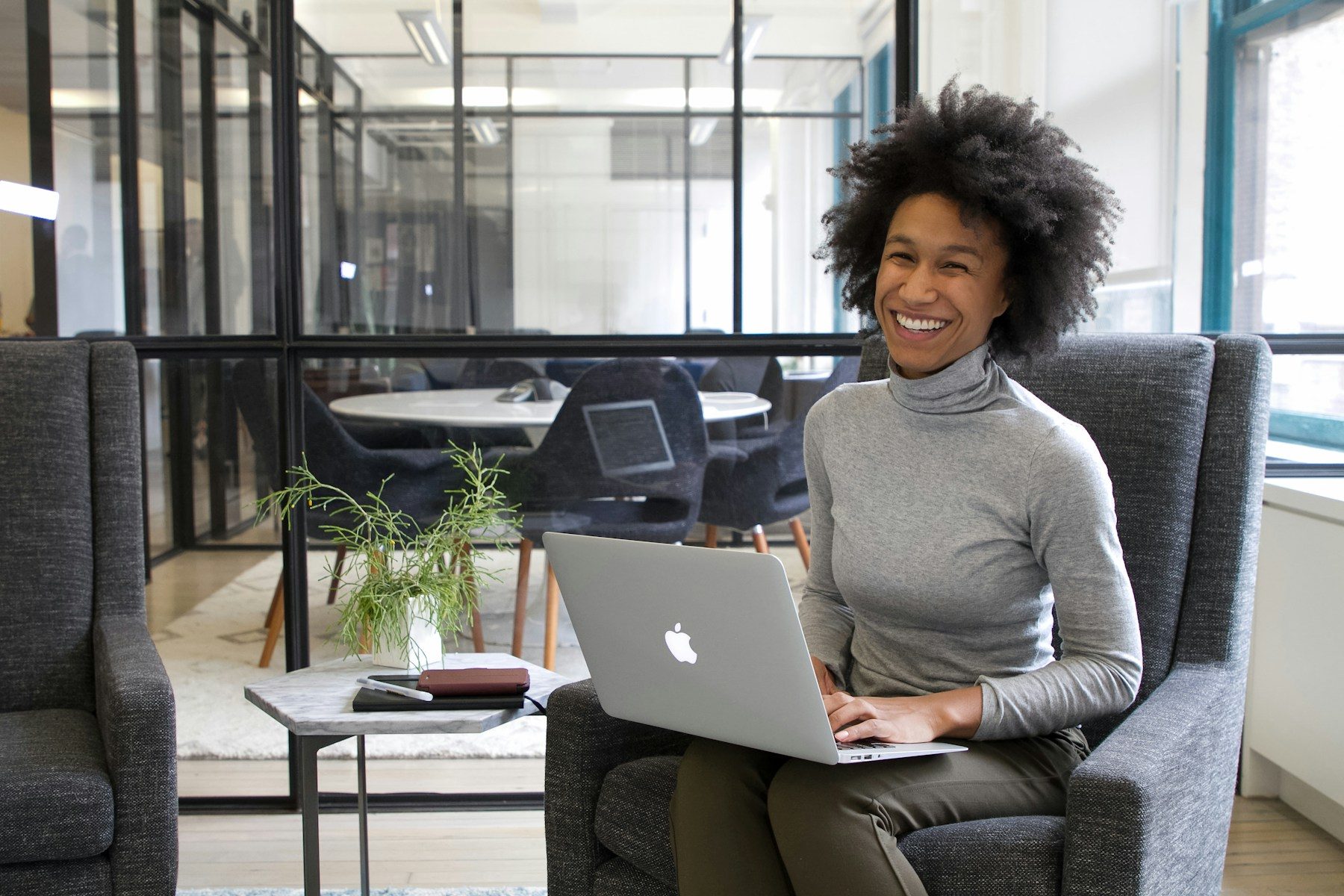 A CSwitch support specialist smiling at her laptop in the office