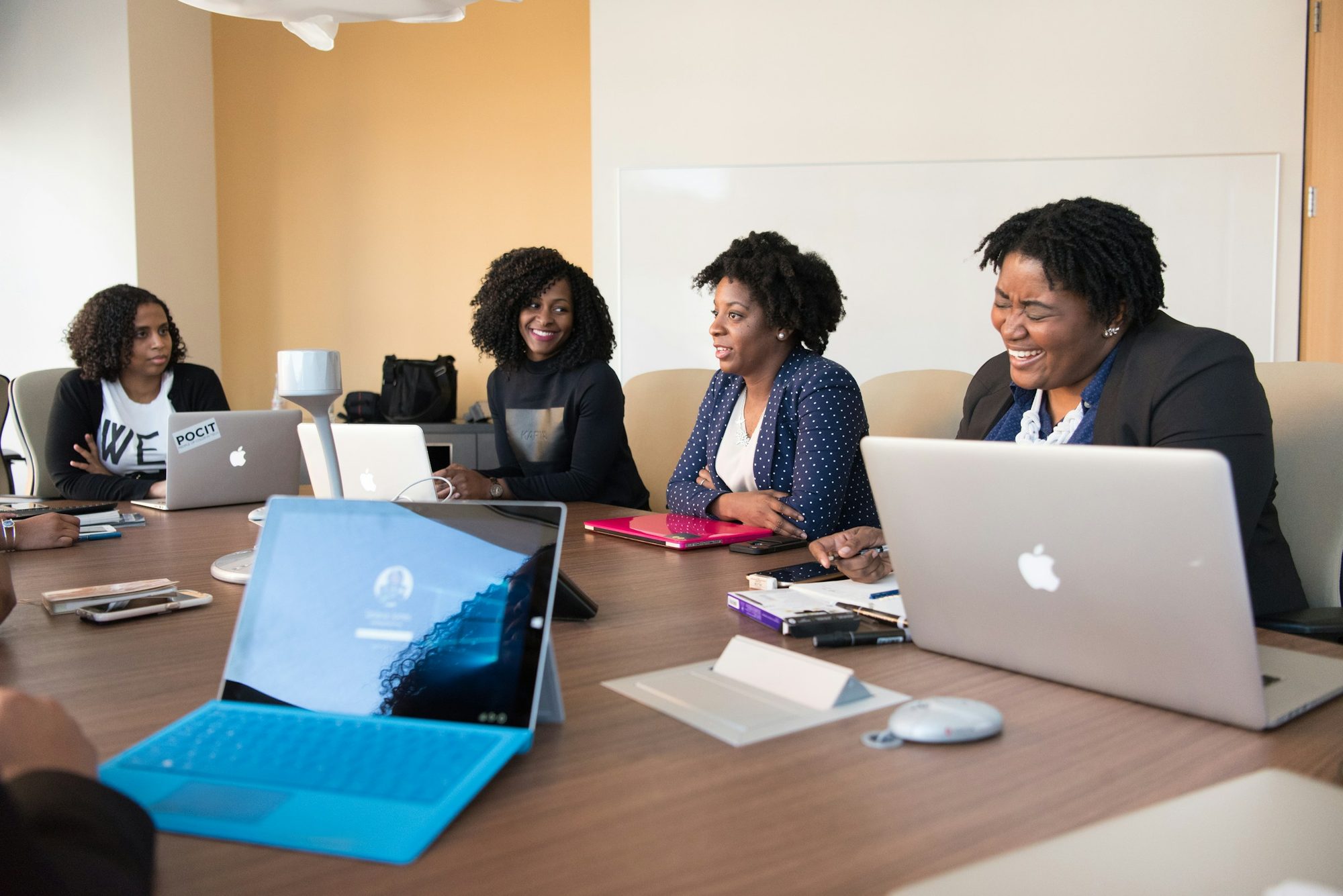A team reviewing payroll together at a table with laptops