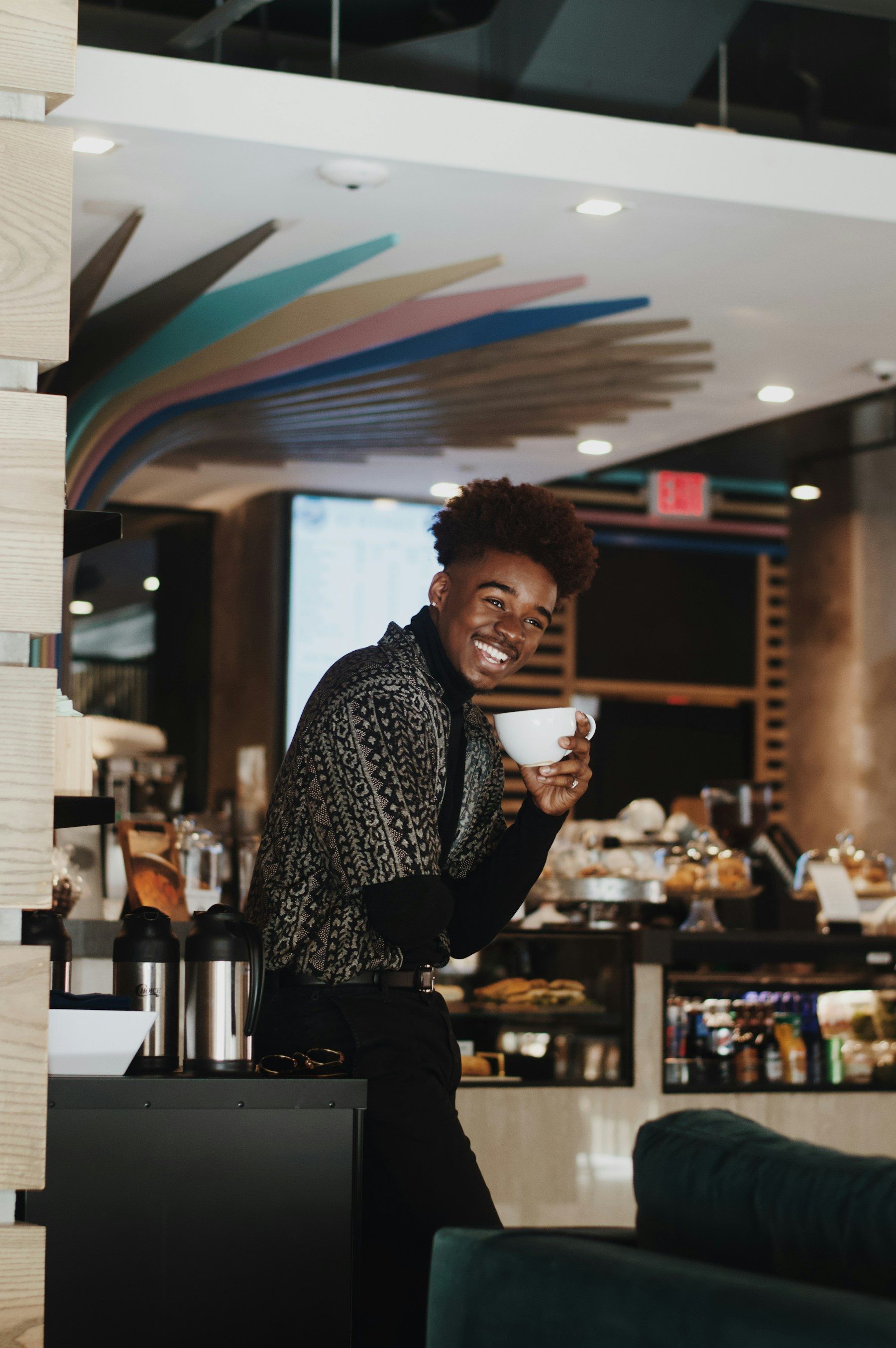 A café owner smiling behind his counter